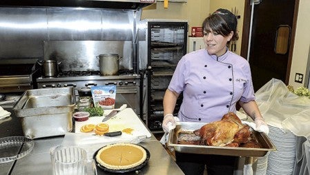 Austin Hy-Vee chef Kristine Wolner pulls a turkey out to plate. 