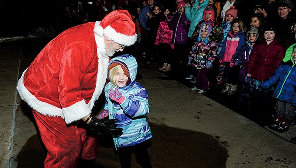 Four-year-old Mallory Lamers couldn’t wait as she rushed out to greet Santa Claus after he landed in an airplane at the Hormel Food Corps. hanger during Christmas in the East Wednesday night. -- Photos by Eric  Johnson photodesk@austindailyherald.com