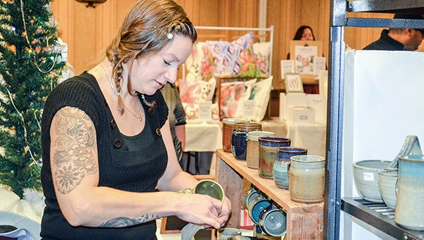 Heather Meyer, owner of Muddy Paw Ceramics, handles a mug during the Indie Craft Market, A Handmade Christmas, Friday evening. -- Photos by Jenae Hackensmith