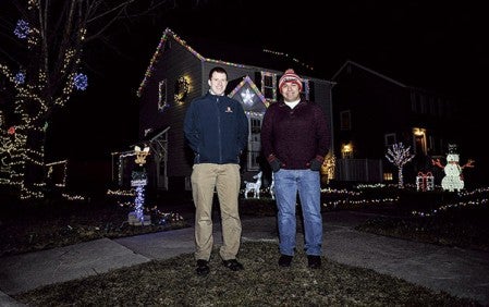 Mike and Freddy Carter stand outside their home where they’ve synced up the Christmas lights of their home to Christmas music playing on the radio.  Eric Johnson/photodesk@austindailyherald.com