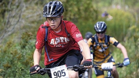 Austin’s Simon Hirst heads up a hill during the freshman and sophomore races this summer at Austin’s Minnesota High School Cycling League’s race at the new course next to Todd Park. Herald file photo