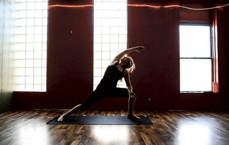 Yoga Studio of Austin owner Lindsey Kepper performs a yoga pose in the newly renovated main room of her business on Main Street Austin. BELOW: A full empty view of the new space.