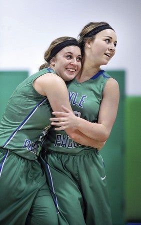 Lyle-Pacelli’s Courtney Walter, left, hugs her sister Brooke Walter after Brooke scored her 1,000th point Friday night against Hope Lutheran at Pacelli. Eric Johnson/photodesk@austindailyherald.com