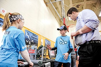 I.J. Holton Intermediate School students Carson Hjelmen and Izzy Hemann tell judge Coby Cost about their robot in the pit area Saturday during the Robotics VEX competition at Austin High School. Hjelmen and Hemann were members of the Holton Engineers A team. 