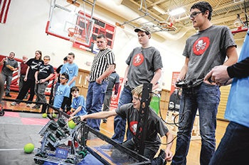 Sam Parks, from left, Seth Wagner and Oliver Andersen, members of one of the Mysterious George teams compete during the Robotics VEX competition Saturday in Packer Gym. 