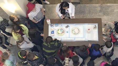 An overhead view shows one of the science demonstrations.
