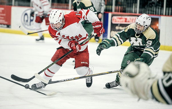 Austin’s Jace Greenman works the puck in front of the Rochester Mayo goal during the second period Thursday night at Riverside Arena. Eric Johnson/photodesk@austindailyherald.com