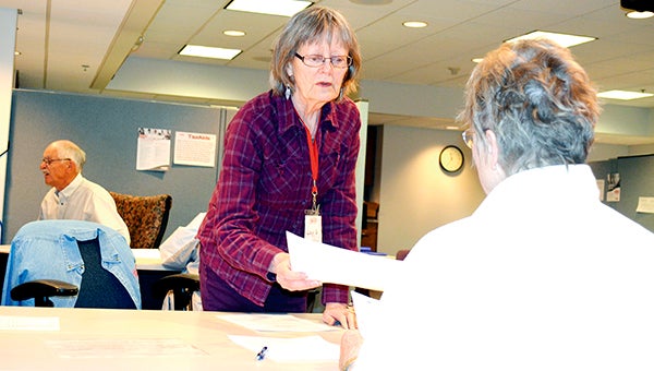 AARP District Coordinator Lucy Gotz (left) helps Daine Chihak of Austin with her taxes last year in the basement of Accentra Credit Union. AARP volunteers are working through April 15 to offer tax help to seniors and low- to moderate-income residents.  -- Herald file photo