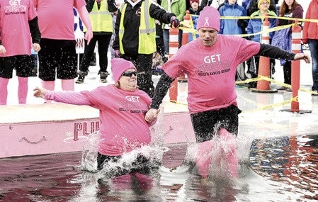 Kelly Joseph and husband Danny make the jump into East Side Lake Saturday during the Polar Plunge. Eric Johnson/photodesk@dailyherald.com