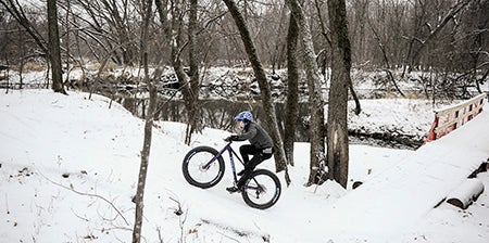 John Burkhart climbs a hill on a Fatbike, a bike that features extra wide tires for snow and offroad riding
