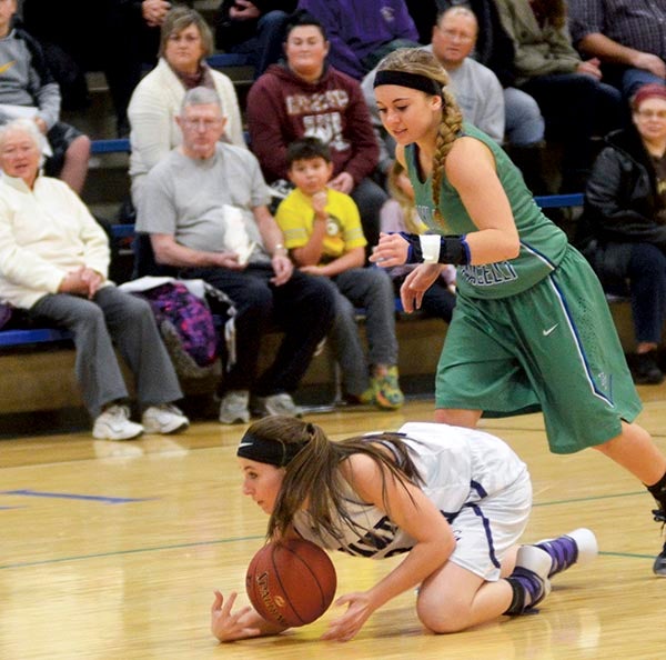 Grand Meadow’s Annika Arndorfer recovers a loose ball as Lyle-Pacelli’s Courtney Walter looks on in Lyle Monday. Rocky Hulne/sports@austindailyherald.com