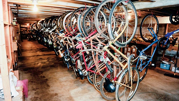 Some older bikes donated for the Red Bike program hang with Rydjor’s other stored bikes in the basement of the business. -- Herald file photos