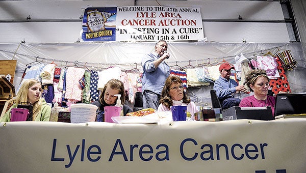 Auctioneer Mick Brooks calls out items last month during the first day of the Lyle Area Cancer Auction in Lyle. Herald file photo