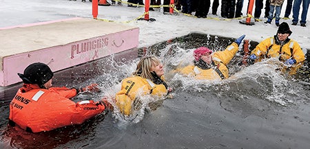 Gail Dennison and Kathy Finley hit the water during their jump at the Polar Plunge Saturday at East Side Lake. Both women were challenged by Gary Ray. 
