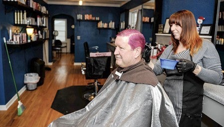 Tim Fritz has his hair dyed by Essence Salon stylist Wendi Howe Tuesday morning, the end result of a fund drive by Hormel plant employees.  