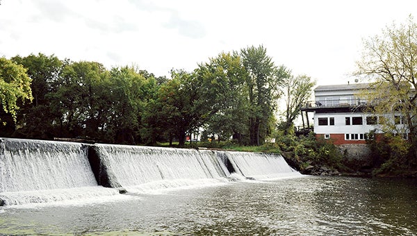 Water flows over Ramsey Dam early last fall. Hormel Foods Corps., who owns the dam, is considering donating it to the city. -- Herald file photo