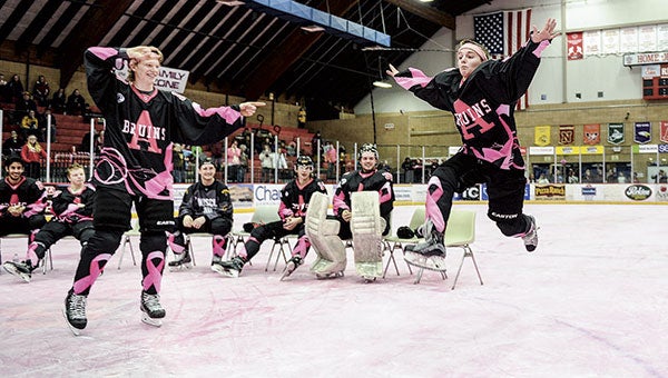 Logan Haskins, right, jumps through the air as he performs a routine with teammate Michael Piehler during the Paint the Rink Pink jersey auction Saturday night. Photos by Eric Johnson/photodesk@austindailyherald.com