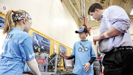 I.J. Holton Intermediate School students Carson Hjelmen and Izzy Hemann tell judge Coby Cost about their robot in the pit area during the Robotics VEX competition at Austin High School in January.