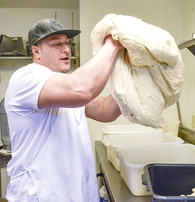 Alex Davis prepares dough for the 12-hour wait where it will rise and be placed in a cooler in preparation of making it into pizza. Alex has worked at his parents’ pizza place since he was 13.