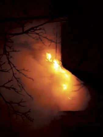 Flames lick the side of an outside wall of a house at 611 First Avenue NW late Saturday night. Eric Johnson/photdoesk@austindailyherald.com