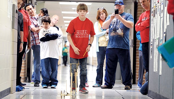 Zach Smith, a seventh-grader at Ellis Middle School watches his egg-tipped scrambler make its first run during the Science Olympiad Saturday at Ellis Middle School. -- Photos by Eric Johnson/photodesk@austindailyherald.com