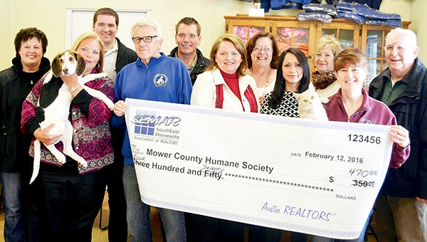 Members from Keller Williams Premier Realty stand with Mower County Humane Society volunteers to present a check to the Mower County Humane Society for $470 Tuesday. -- Jenae Hackensmith/jenae.hackensmith@austindailyherald.com