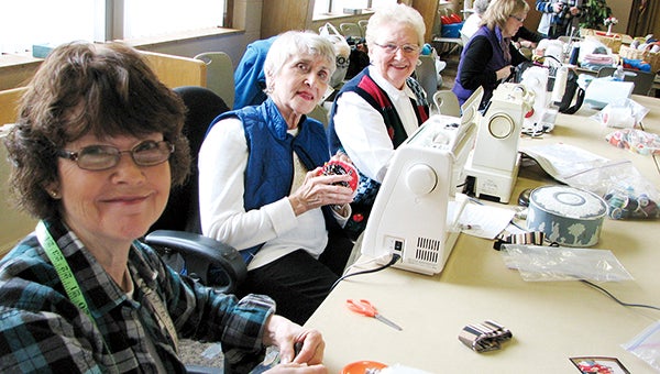 Meridee Ofstedahl, Carole Lembrick and Project Coordinator Darlene Berhow work at machines sewing walker caddies for a local health care center during a mission workshop at Westminster Presbyterian Church.  -- Photo provided