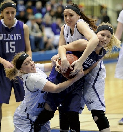 Grand Meadow’s Masie Voigt, left, and Rylee Stickrod force a jump ball on Goodhue’s Megan Ryan in Mayo Civic Center Monday. Rocky Hulne/sports@austindailyherald.com