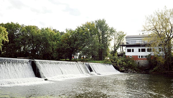 Water flows over Ramsey Dam early last fall. Hormel Foods Corp., owns the dam and is considering selling the dam to the city. -- Herald file photo