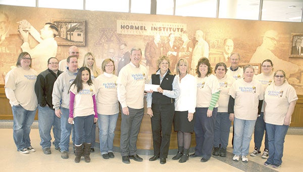 Hormel Foods Corp. Austin plant workers with the Helping Hands Committee present a more than $12,000 donation to The Hormel Institute on Thursday. Photo provided
