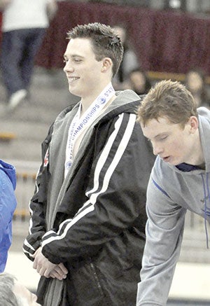 Ben Walker stands on the podium after taking third in the 100-butterfly.   Photos provided