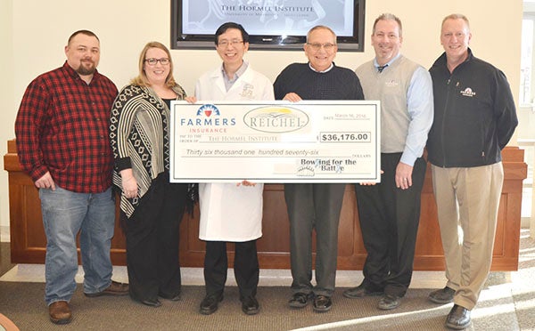 Tom Gillard of Farmers Insurance presents a $36,176 donationWednesday for prostate cancer research to The Hormel Institute, University of Minnesota. Executive Director Dr. Zigang Dong accepted the donation on behalf of the Institute. The donation was raised March 5 at the second “Bowling for the Battle” fundraiser to support the Institute’s prostate cancer research. Pictured are (left to right) Jason Maschka; Laura Maschka, of Farmers Insurance; Dr. Zigang Dong, of The Hormel Institute; Tom Gillard, Pat Andreas, and Jim Benson, all of Farmers Insurance. Photo provided