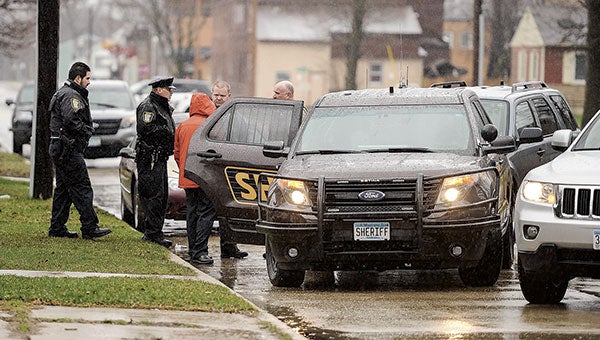 Austin Police and Mower County Sheriff’s Department deputies talk outside of a home on 10th Street Northeast Thursday morning. Eric Johnson/photodesk@austindailyherald.com
