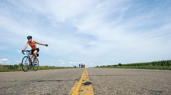A cyclist waves as she passes on the way to LeRoy last yearduring the Bicycling Across Minnesota tour.  White the tour doesn’t come to the Austin area it will start and end in Waseca. Herald file photo