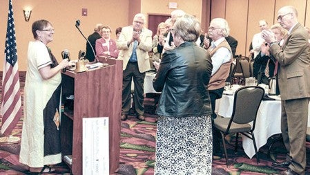 Austin Rotary members applaud Kathy Stutzman during a meeting on Monday at the Holiday Inn Conference Center. She received the prestigious Service Above Self Award.