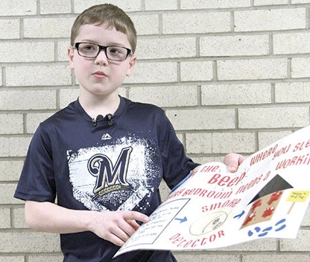 Southgate Elementary School fourth-grader Brandon Kuhnke, 9, talks about his winning poster for the 2015 Minnesota State Fire Chiefs Association Poster Contest at the school Tuesday. Jason Schoonover/jason.schoonover@austindailyherald.com
