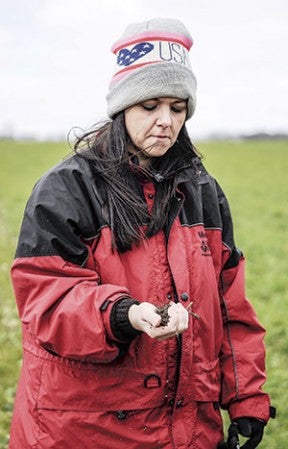 Andrea Horseman, a soil conservationist with the Natural Resources Conservation Service examines soil from a field belonging to Tom Cotter. 