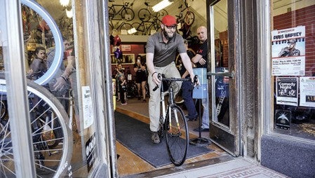 Kelly Nesvold rides his new bike out of Rydjor Bike Shop Wednesday evening after he was surprised by the gift bought through money donated from friends.  Eric Johnson/photodesk@austindailyherald.com