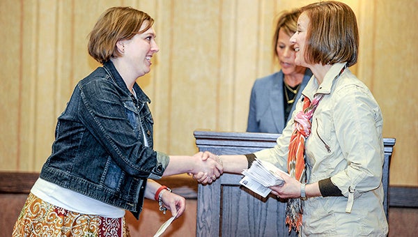 Catherine Haslag accepts a donation from the United Way of Mower County on behalf of the Science Fair Mentors Program from Merrilyn Berg Wednesday during the Campaign Victory Part at the Hormel Historic Home.  -- Photos by Eric Johnson/photodesk@austindailyherald.com