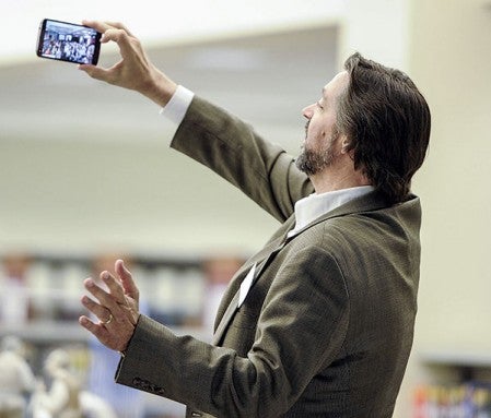 Author Allen Eskens takes a selfie with the crowd gathered at the Austin Public Library for his presentation Thursday night. Photos by Eric Johnson/photodesk@austindailyherald.com