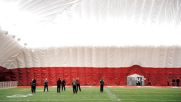 The Austin softball team warms up under the dome over Art Hass Stadium before a winter league game. -- Herald file photos