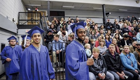 Anderson Gois Siqueira, right and Jorman A. Calle De Oliveira lead the first group of graduates into the Riverland gym Friday afternoon. Eric Johnson/photodesk@austindailyherald.com