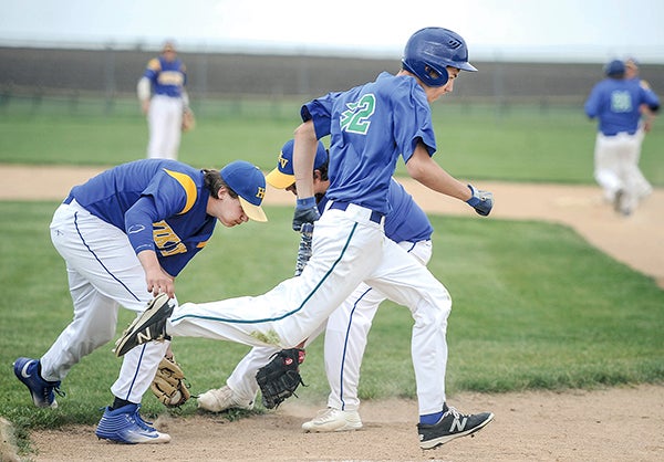 Lyle-Pacelli’s Jed Nelson races past Hayfield’s Adam Fjerstad, left, and first baseman Brady Dahl on a bunt Friday in Hayfield. Eric Johnson/photodesk@dailyherald.com