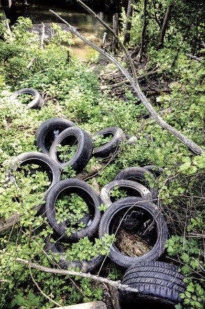 Discarded tires lay next to Ochard Creek south of Austin Friday. Eric Johnson/photodesk@austindailyherald.com