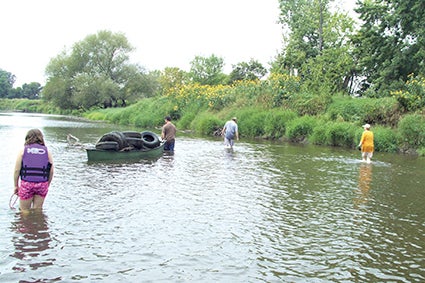Volunteers with the Larry Callahan group clean the Cedar River during 2013 in Lyle Township, south of Austin. 