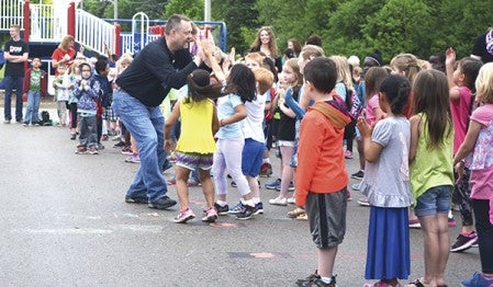 Neveln Elementary School Principal Dewey Schara celebrates his dance-off victory with a group of students at Woodson Kindergarten Center Friday morning. Alex Smith/alex.smith@austindailyherald.com 