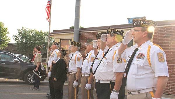 Veterans, pictured right, salute as Norm Hecimovich raises the flag outside the Veterans of Foreign Wars Club Monday morning.  Photos by Jason Schoonover 