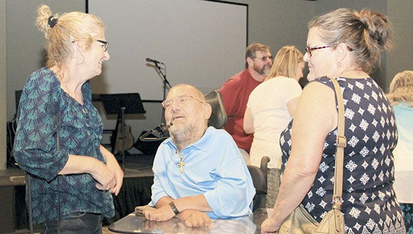Tamera Carroll Meres, left, and Deb Swanson, right, talk to Randy Krulish during an event marking the 50th anniversary of a diving accident left Krulish as a quadriplegic. Since the accident, Krulish has written a book and become a public speaker, where he talks about the power of a positive attitude. Jason Schoonover/jason.schoonover@austindailyherald.com