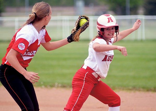 Austin’s Kelsey Sederquest attempts to avoid the tag from Mankato West first baseman Krista Goerger in Todd Park Monday. Rocky Hulne/sports@austindailyherald.com