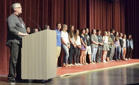 Teacher Barry Brobeck speaks to the audience as award-winning art students line the stage at the annual art show at Austin High School Wednesday afternoon.  Alex Smith/alex.smith@austindailyherald.com